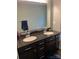 Double vanity bathroom with granite countertops and dark wood cabinets at 7308 Gallery Pointe Ln, Charlotte, NC 28269