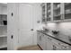 Butlery with white cabinets, dark countertop, and glass-front cabinets at 5313 Mint Harbor Way # 0312, Charlotte, NC 28269