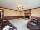 Living room featuring a brick fireplace, wood paneling, and comfortable seating at 6614 Alexander Hall Dr, Charlotte, NC 28270