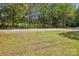 Image shows a grassy area with trees and a gravel driveway at 804 Sowell St, Lancaster, SC 29720