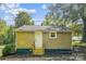 Rear view of a small house with tan siding, a white door, and a wooden deck at 804 Sowell St, Lancaster, SC 29720
