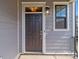Dark brown front door with a sidelight window and exterior light at 10193 Meeting House Nw Dr, Huntersville, NC 28078