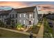 Gray two-story townhome with front porch and landscaping at sunset at 10193 Meeting House Nw Dr, Huntersville, NC 28078