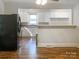 Kitchen with white cabinets, breakfast bar, and black refrigerator at 305 N Milford Dr, Salisbury, NC 28144