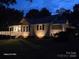 Charming house exterior at night with deck and landscape lighting at 1176 Shearers Rd, Mooresville, NC 28115