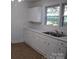 Bright kitchen featuring white cabinets, double sink, and vinyl flooring at 2124 W Main St # C, Albemarle, NC 28001