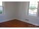 Simple bedroom with hardwood floors and two large windows at 2124 W Main St # C, Albemarle, NC 28001