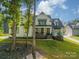 Two-story farmhouse-style home with white siding and a black roof at 540 Kenway Loop, Mooresville, NC 28117