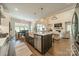Open concept kitchen with island, farmhouse sink, and view to living room at 540 Kenway Loop, Mooresville, NC 28117