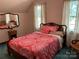 Bedroom with a wooden bed frame and two windows at 701 Whippoorwill Ln, Concord, NC 28025
