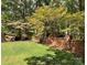 Landscaped backyard with a brick wall and lush greenery at 701 Whippoorwill Ln, Concord, NC 28025
