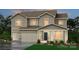 Two-story home with beige siding, two-car garage, and landscaping at 220 E Warfield Dr, Mooresville, NC 28115