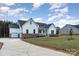 White farmhouse with a two-car garage and a spacious driveway at 1336 Sage Pine Cir # 21, Clover, SC 29710