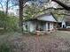 Small cottage with a front porch and overgrown yard at 213 Belt Dr, Lowell, NC 28056