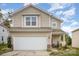 Tan two-story house with a two-car garage and well-maintained landscaping at 12009 Downy Birch Rd, Charlotte, NC 28227