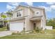 Tan two-story house with a two-car garage and well-maintained landscaping at 12009 Downy Birch Rd, Charlotte, NC 28227
