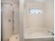 Bathroom with shower and bathtub combo, and large window at 12009 Downy Birch Rd, Charlotte, NC 28227
