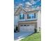 Two-story townhome with gray siding, stone accents, and a two-car garage at 145 Beacon Dr # F, Mooresville, NC 28117