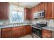 Kitchen with wood cabinets, granite counters, and stainless steel appliances at 424 S College Ave, Newton, NC 28658
