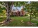 Brick home with a large tree and manicured lawn at 424 S College Ave, Newton, NC 28658
