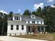 Stunning two-story farmhouse with white siding, a covered porch, and manicured lawn at 0001 Bolton Rd, Catawba, NC 28609