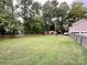 Large backyard with green lawn, trees, and a fence at 142 Scotland Dr, Mooresville, NC 28115