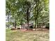 Two story house nestled among lush trees and landscaping at 142 Scotland Dr, Mooresville, NC 28115