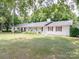 White brick ranch house with a long front porch and American flag at 8909 Highway 218 Hwy, Marshville, NC 28103