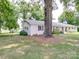 Ranch home with white brick exterior, metal roof, and large tree in front yard at 8909 Highway 218 Hwy, Marshville, NC 28103