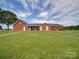 Back view of brick ranch house with a patio and large yard at 8510 Olive Branch Rd, Marshville, NC 28103