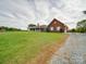 Brick ranch house with a gravel driveway and a large lawn at 8510 Olive Branch Rd, Marshville, NC 28103