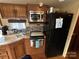 RV kitchen features a microwave, stovetop, double sink, and black refrigerator at 145 Marina Dr, New London, NC 28127