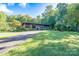 Ranch style home with a long driveway and green lawn at 501 Journey Sw St, Concord, NC 28025