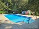 Sparkling, rectangular in-ground pool with surrounding patio at 4808 Asbury Dr, Monroe, NC 28110