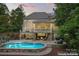 Home exterior showcasing a pool, patio, and screened porch at dusk at 235 Grey Rd, Davidson, NC 28036