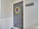 Gray front door with a floral wreath at 11719 Ridgeway Park Dr, Charlotte, NC 28277