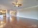 Large living room with hardwood floors, ceiling fan, and views to kitchen and stairs at 131 Renville Pl, Mooresville, NC 28115