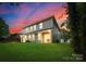 Two-story home with a backyard, illuminated at dusk at 1142 Leigh Cir, Charlotte, NC 28216