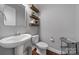 Stylish powder room with pedestal sink and floating shelves at 453 Galbreath Ct, Fort Mill, SC 29708