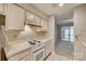Bright kitchen features white cabinets, electric stove, and access to a sunroom at 151 Cedar Hollow St, Fort Mill, SC 29715