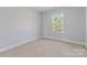 Bright bedroom with neutral walls and carpet, featuring a large window at 1026 Heath Helms Rd, Monroe, NC 28110