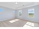 Well-lit bedroom featuring carpet flooring and multiple windows with scenic views at 1026 Heath Helms Rd, Monroe, NC 28110