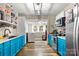 Bright teal kitchen with stainless steel appliances and a laundry area at 515 Suttle St, Shelby, NC 28150