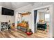 Bright living room featuring hardwood floors, a TV, and an open doorway to a bedroom at 515 Suttle St, Shelby, NC 28150