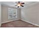 Well-lit bedroom featuring carpet flooring, ceiling fan, and large window at 225 Greenway Ave, Cherryville, NC 28021