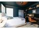 Dark-walled bedroom with a built-in workspace and king-size bed at 272 Millingport Ln, New London, NC 28127