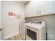 Bright laundry room with washer, dryer, and upper cabinets at 2014 Newstyle Way, Tega Cay, SC 29708