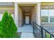 Brick home's entrance with covered porch, metal railing, and landscaping at 2014 Newstyle Way, Tega Cay, SC 29708