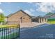Brick house back with patio, fenced yard, and gravel landscaping at 2014 Newstyle Way, Tega Cay, SC 29708