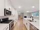 Kitchen with white cabinets, stainless steel appliances, and hardwood floors at 216 E Warfield Dr, Mooresville, NC 28115